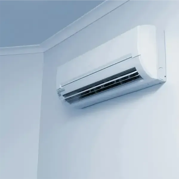 Wall-mounted white air conditioner above a window in a light blue room