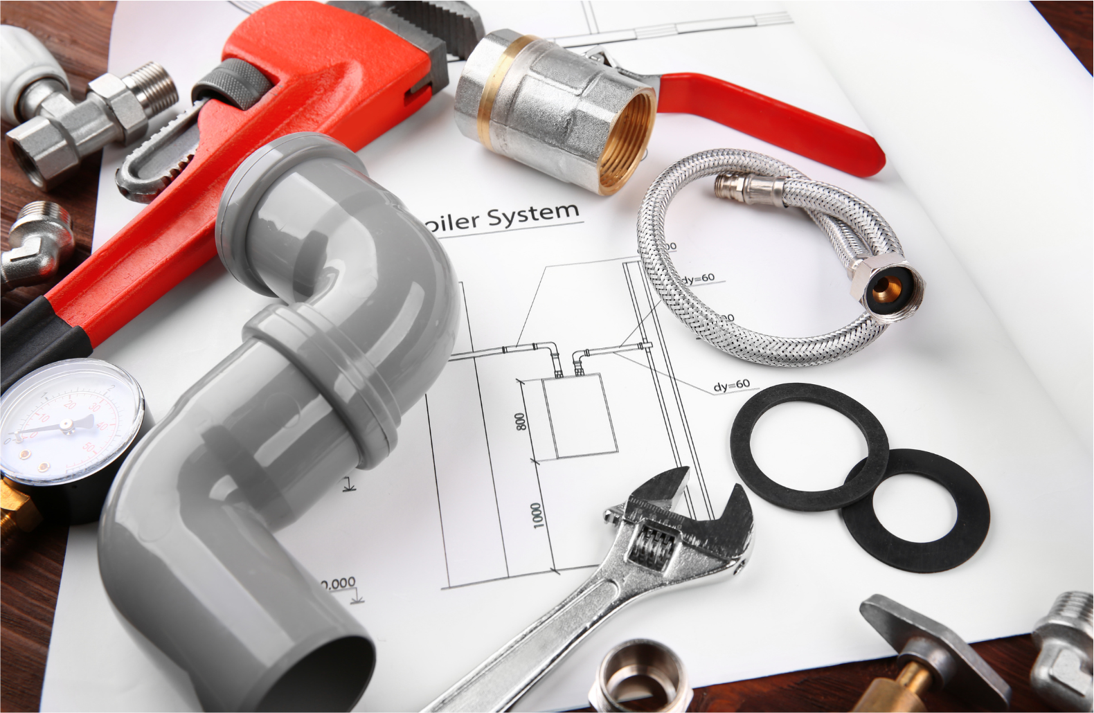 Plumbing tools and parts on a bathroom floor plan, including pipes, wrench, tape measure, and fittings