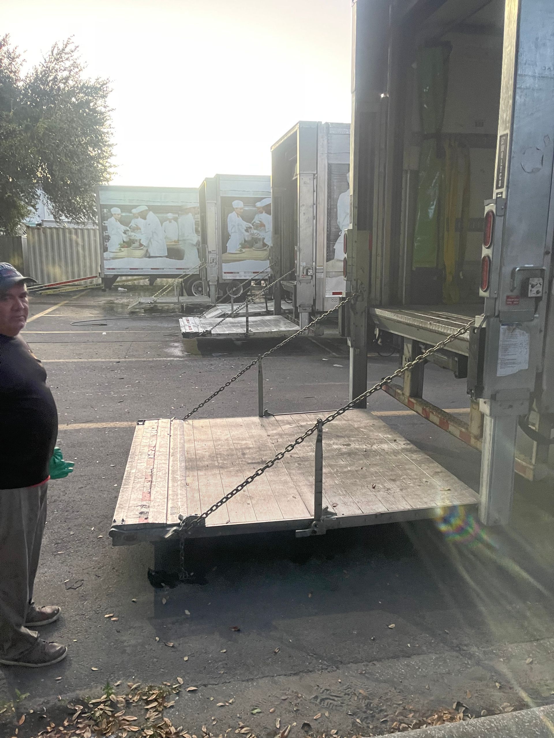 Truck loading dock with a raised wooden platform and a person standing nearby