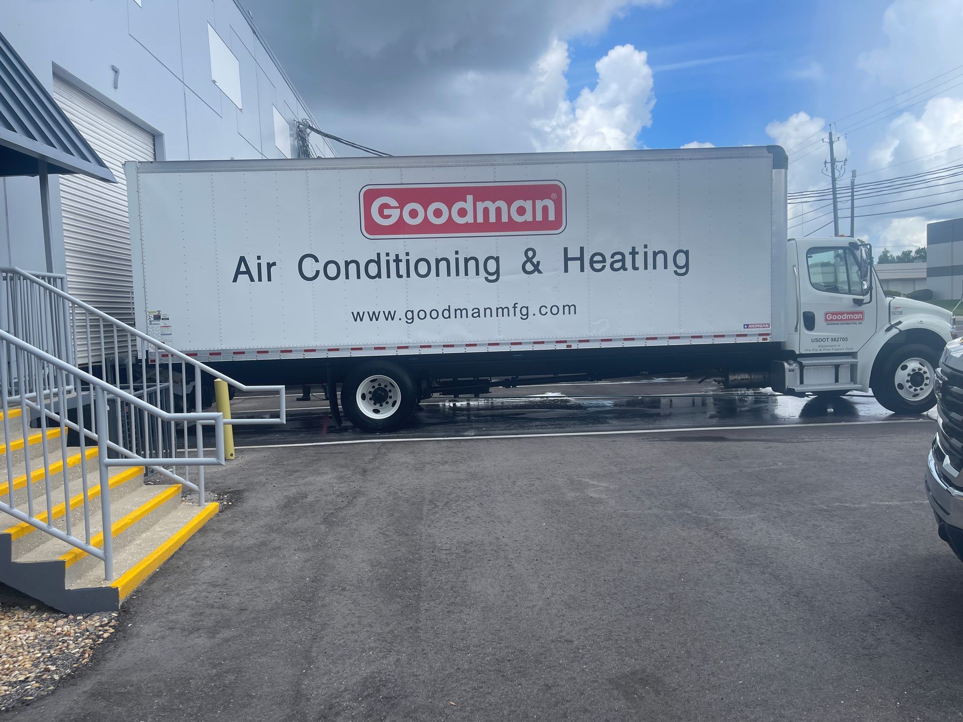 Goodman Air Conditioning & Heating truck parked beside a building on a paved lot