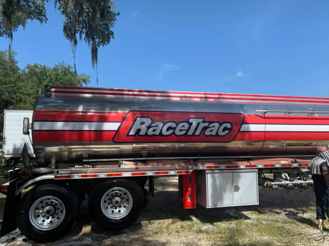 Red RaceTrac fuel tanker trailer parked outdoors under a blue sky
