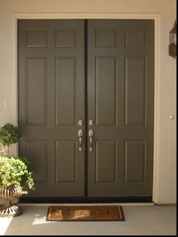 A pair of double doors with a door mat on the floor.