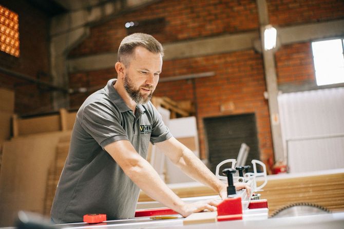 Man working with tools at a workbench in a brick-walled workshop