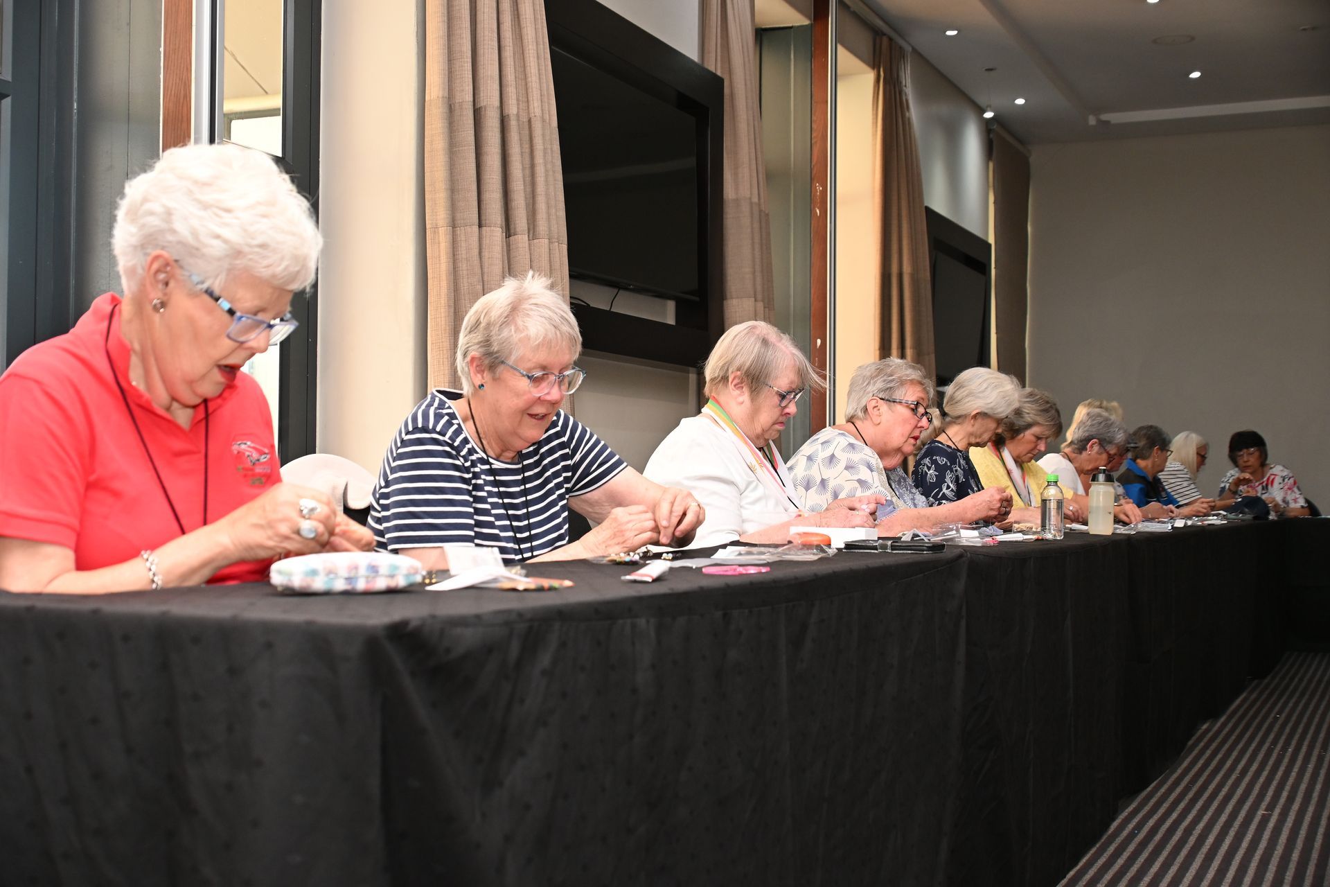 People seated at a long table signing papers in a meeting room