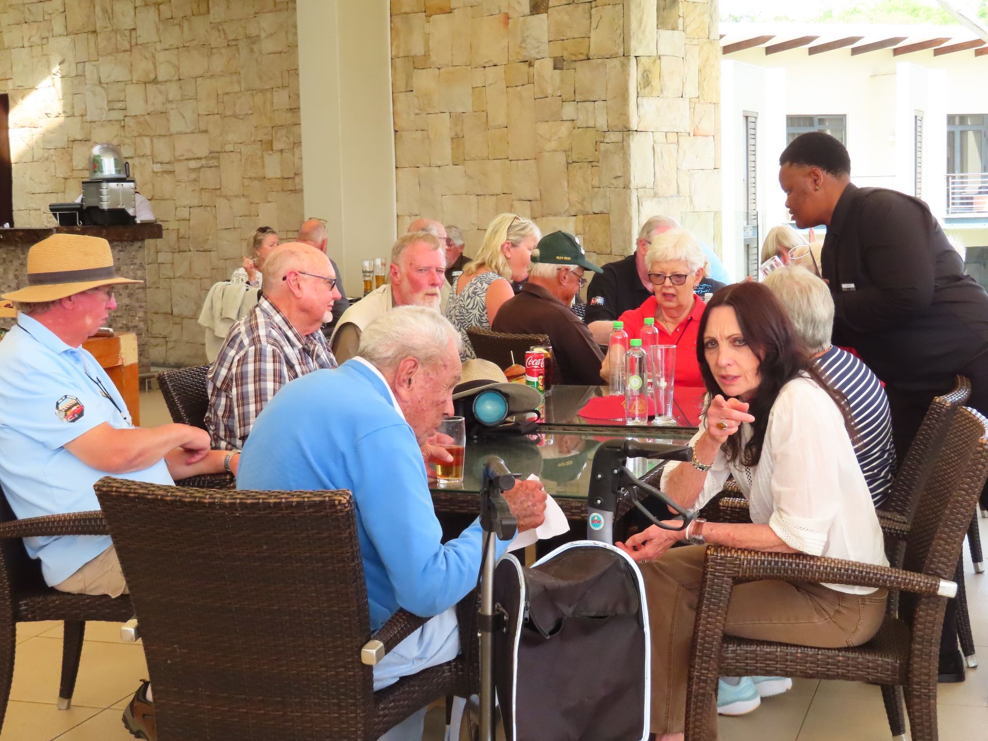 Group seated at an outdoor café table while a server takes an order