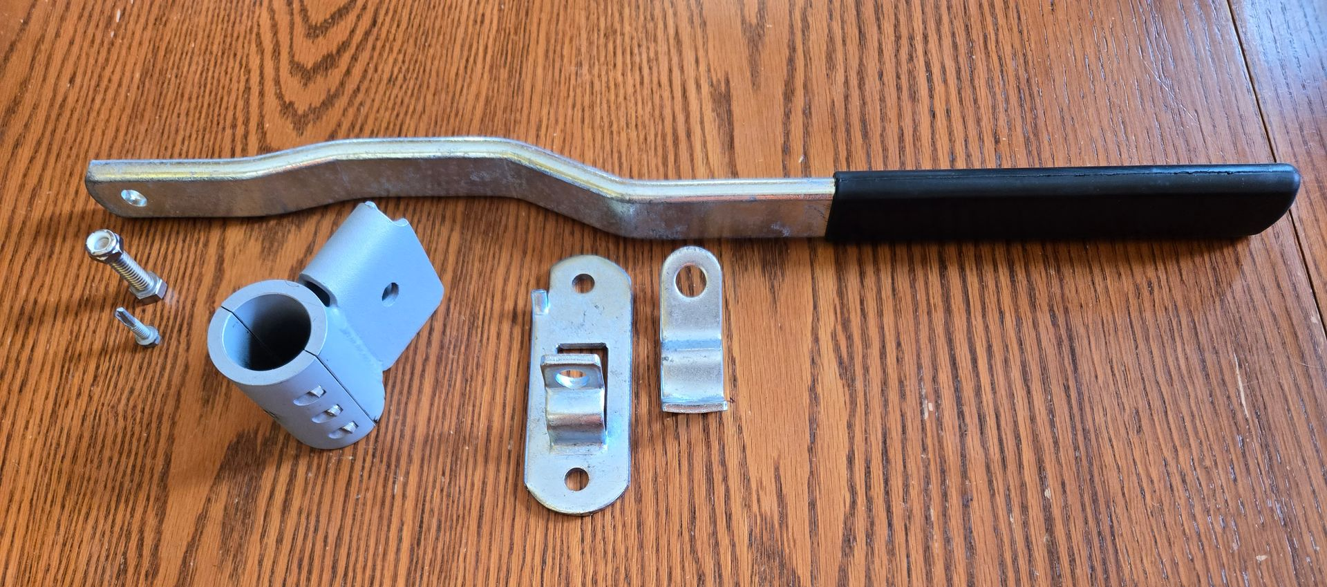 Two metal car brake tools with black handles on a brown surface.