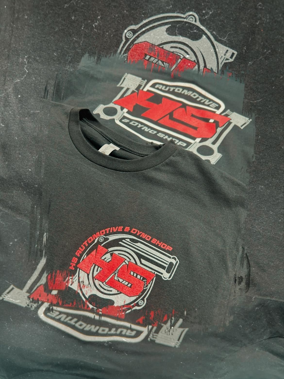 A stack of black t-shirts featuring the red and white