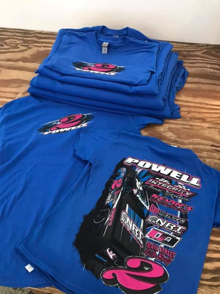A stack of royal blue T-shirts featuring a race car graphic and the name
