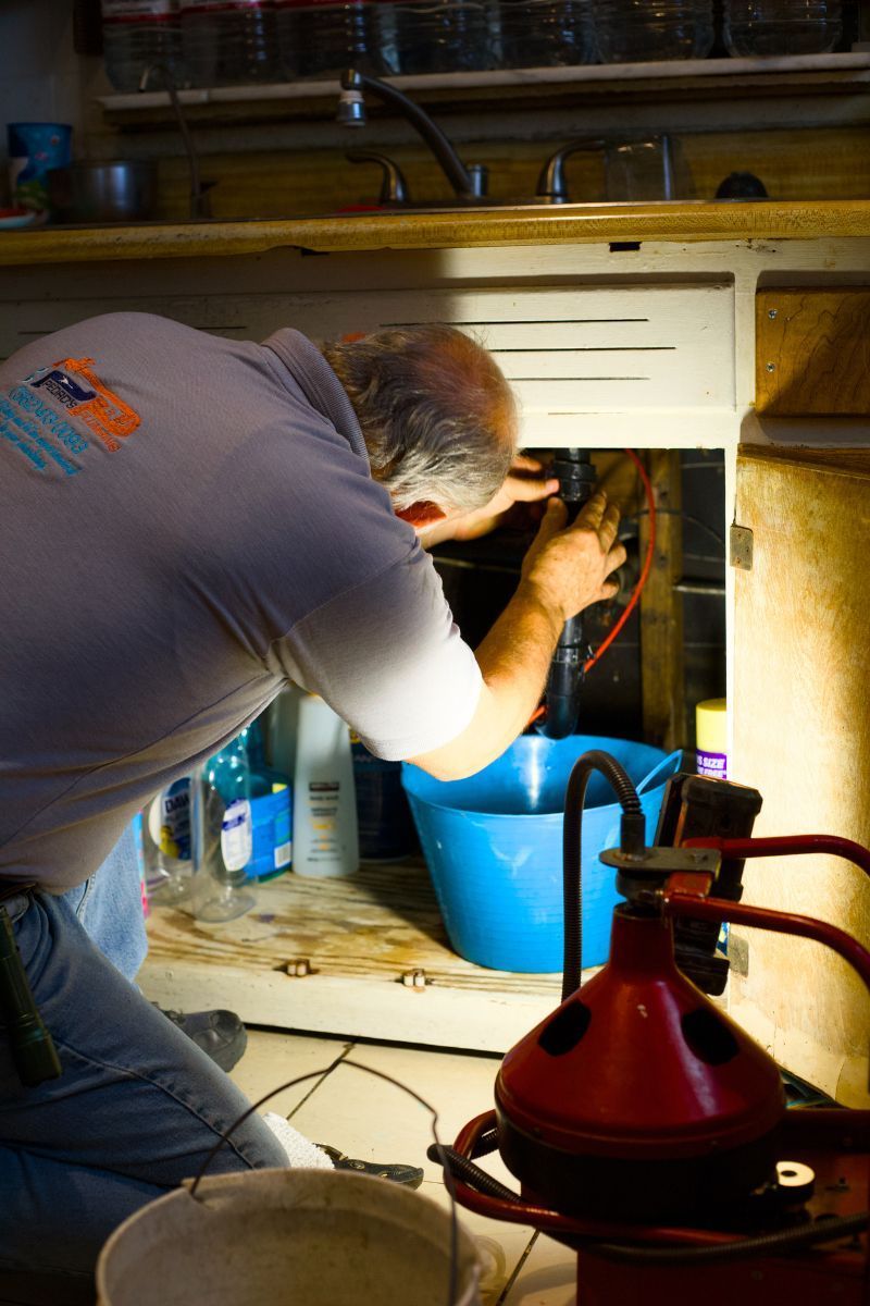 Licensed Pedro's Plumbing technician inspecting plumbing beneath a kitchen sink in Los Angeles