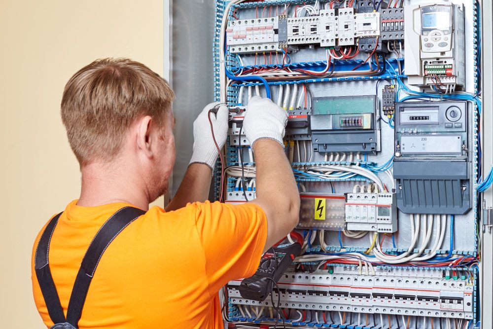 Engineer Tests Power High Voltage Three Phase Circuit Box With Multimeter — PRO Solar & Electrical In Newcastle, NSW