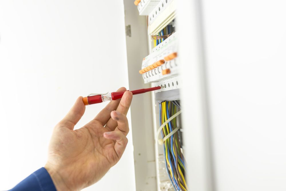Electrician Testing An Electrical Circuit Board With A Handheld Tester — PRO Solar & Electrical In Port Stephens, NSW