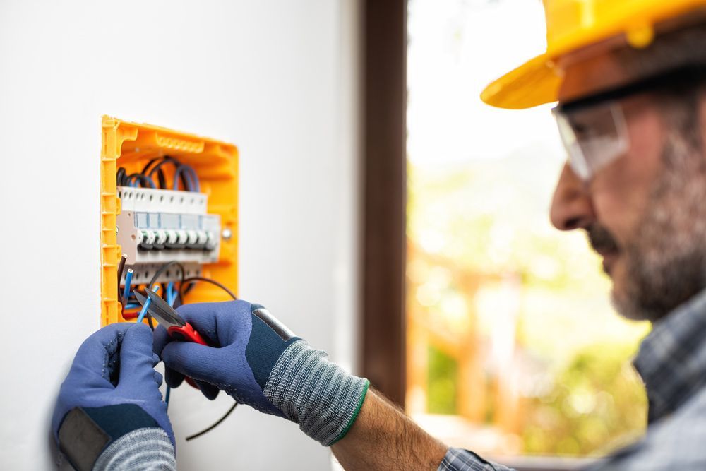 Electrician At Work Prepares Electrical Cables In The Switchboard — PRO Solar & Electrical In Newcastle, NSW