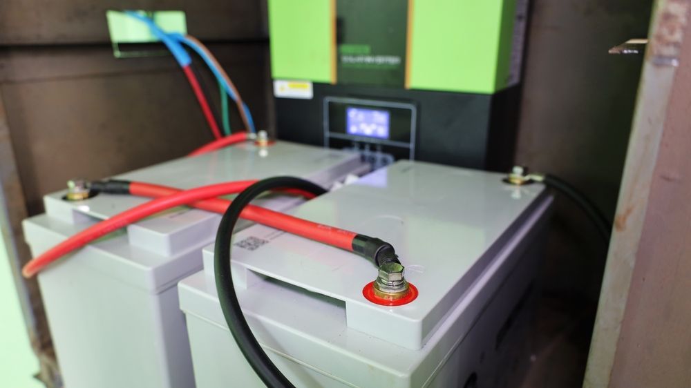 Two Batteries Are Connected To A Charger In A Room — PRO Solar & Electrical In Maitland, NSW