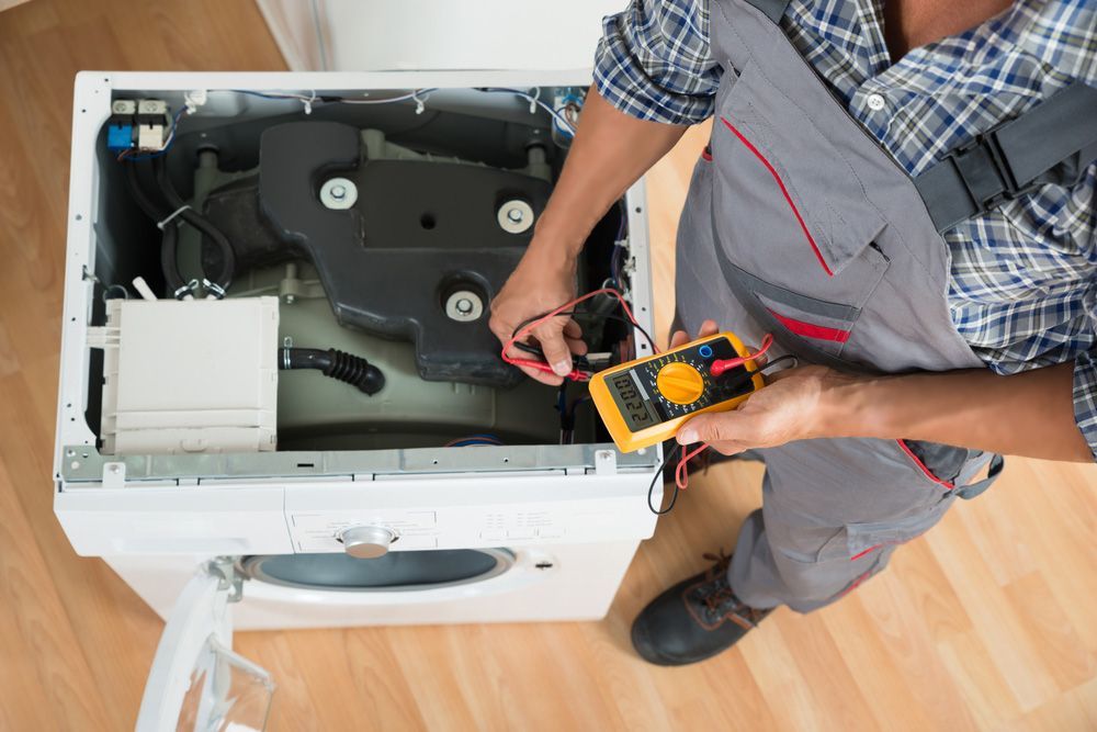 Electrician Checking Power In An Appliance — PRO Solar & Electrical In Newcastle, NSW