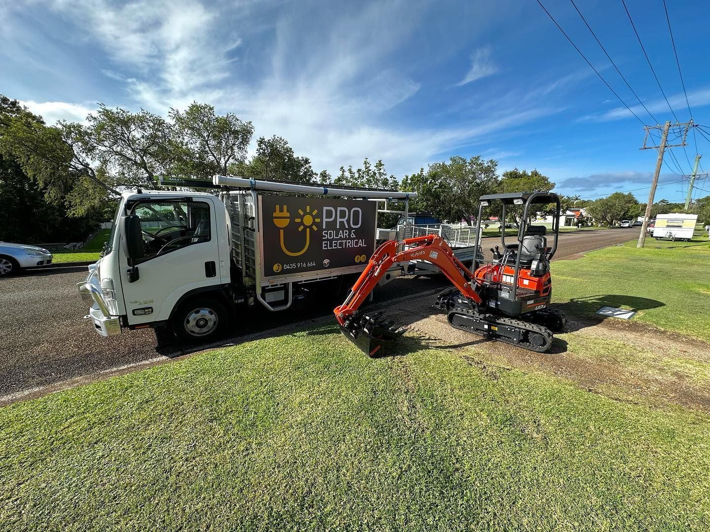 Pro Solar Electrical Vehicle Outside With Red Excavator — PRO Solar & Electrical In Newcastle, NSW