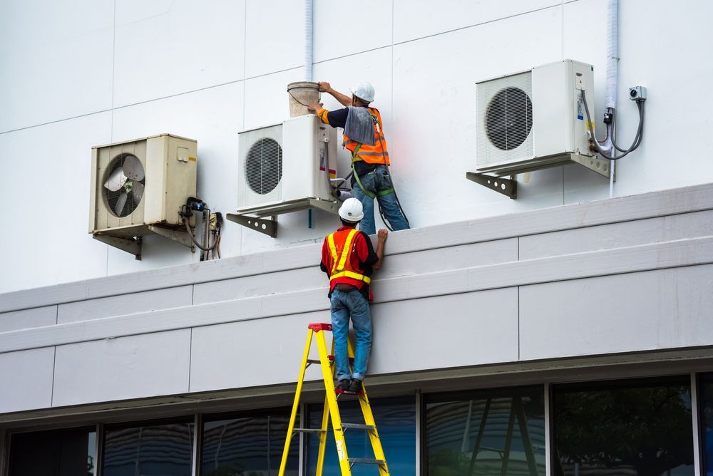 Air Conditioning Technician Are Servicing Air Conditioning Units — PRO Solar & Electrical In Newcastle, NSW