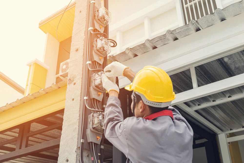 A Man Wearing A Hard Hat Is Working On A Building — PRO Solar & Electrical In Port Stephens, NSW