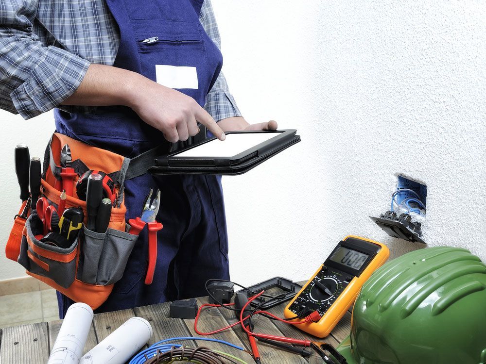 Young electrician working on tablet — Electricians Near Me in Newcastle NSW