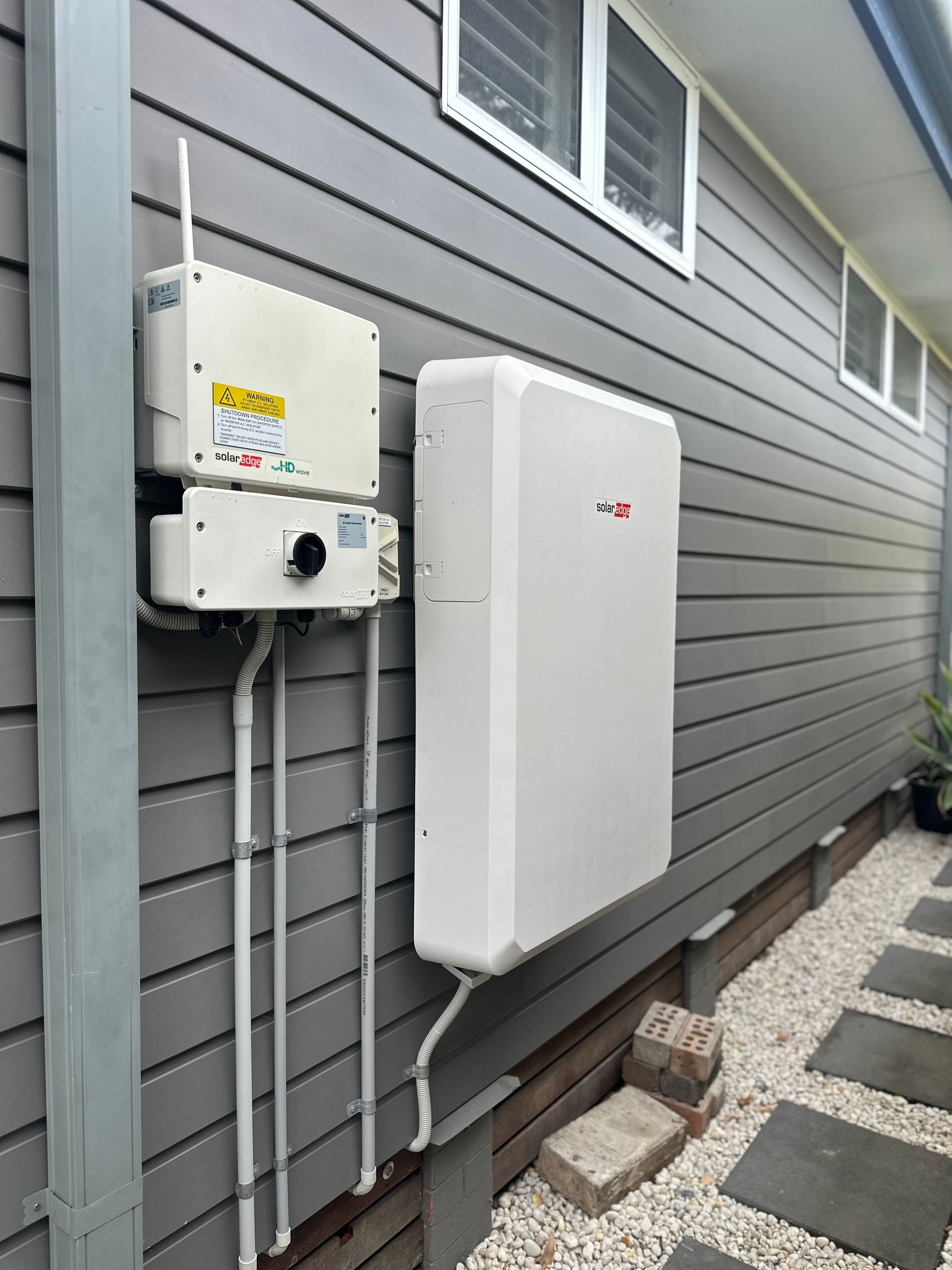A Battery Is Installed On The Side Of The Hosue— PRO Solar & Electrical In Maitland, NSW