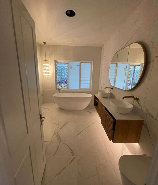 A Bathroom With A Bathtub, Sinks, Toilet And Mirror — PRO Solar & Electrical In Newcastle, NSW