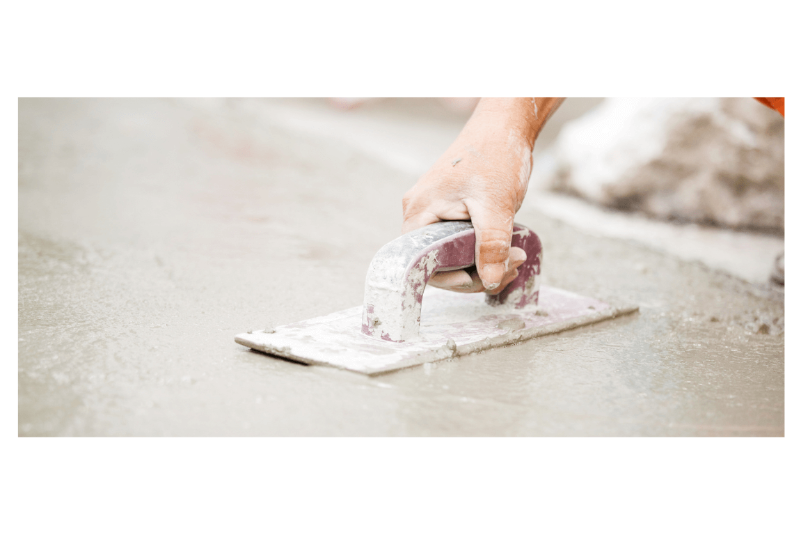 Hand smoothing wet concrete with a trowel on a fresh sidewalk