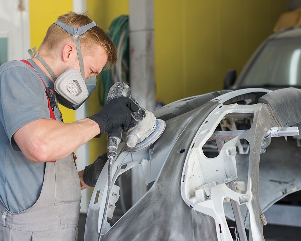 Mechanic Repairing Car Bumper — Cincinnati, OH — Mark’s Auto Body