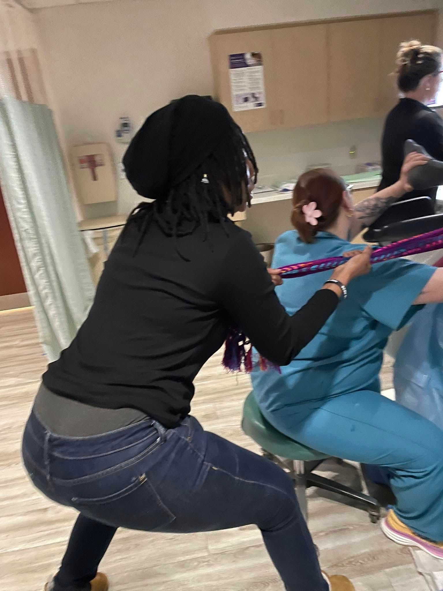 People pulling on a rope in what appears to be a hospital room.