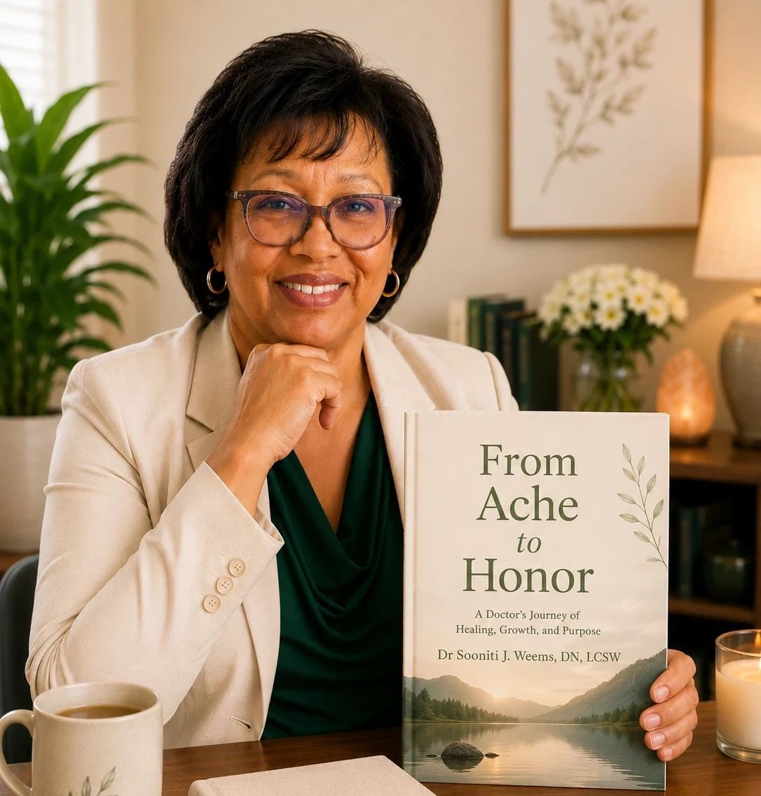 Woman smiling beside a book titled “From Ache to Honor” in a warm, home-like setting