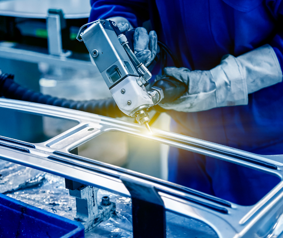 Worker welding metal frame in an industrial factory, with bright sparks and blue protective gloves
