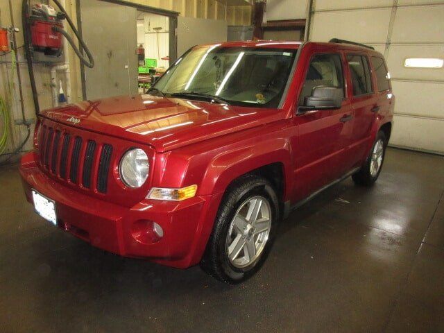 Red Jeep Renegade parked indoors, viewed from the front-left side.