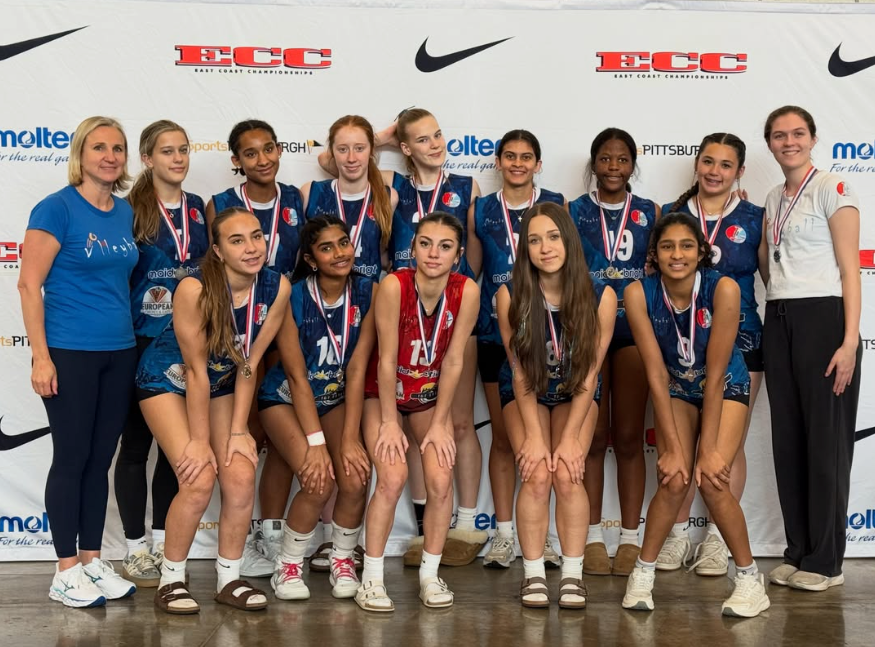 Women’s volleyball team posing with medals and trophy at an awards ceremony