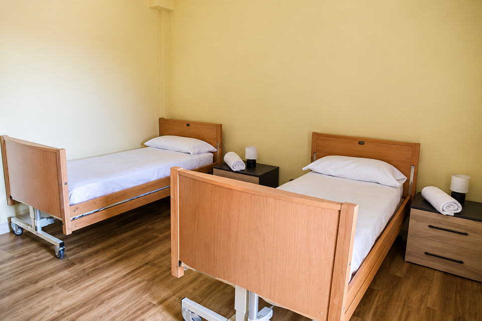 Due letti singoli con lenzuola bianche in una camera da letto luminosa con pareti verde chiaro.