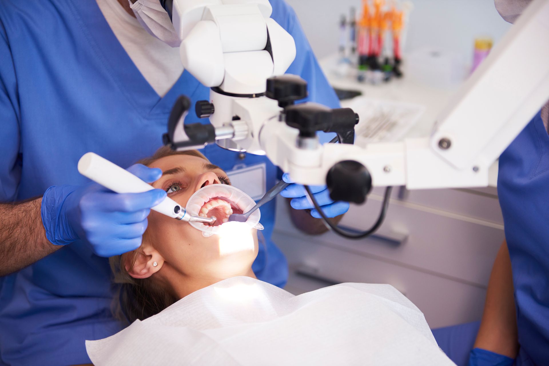 Dentist examining a patient’s teeth with a mirror in a bright dental clinic