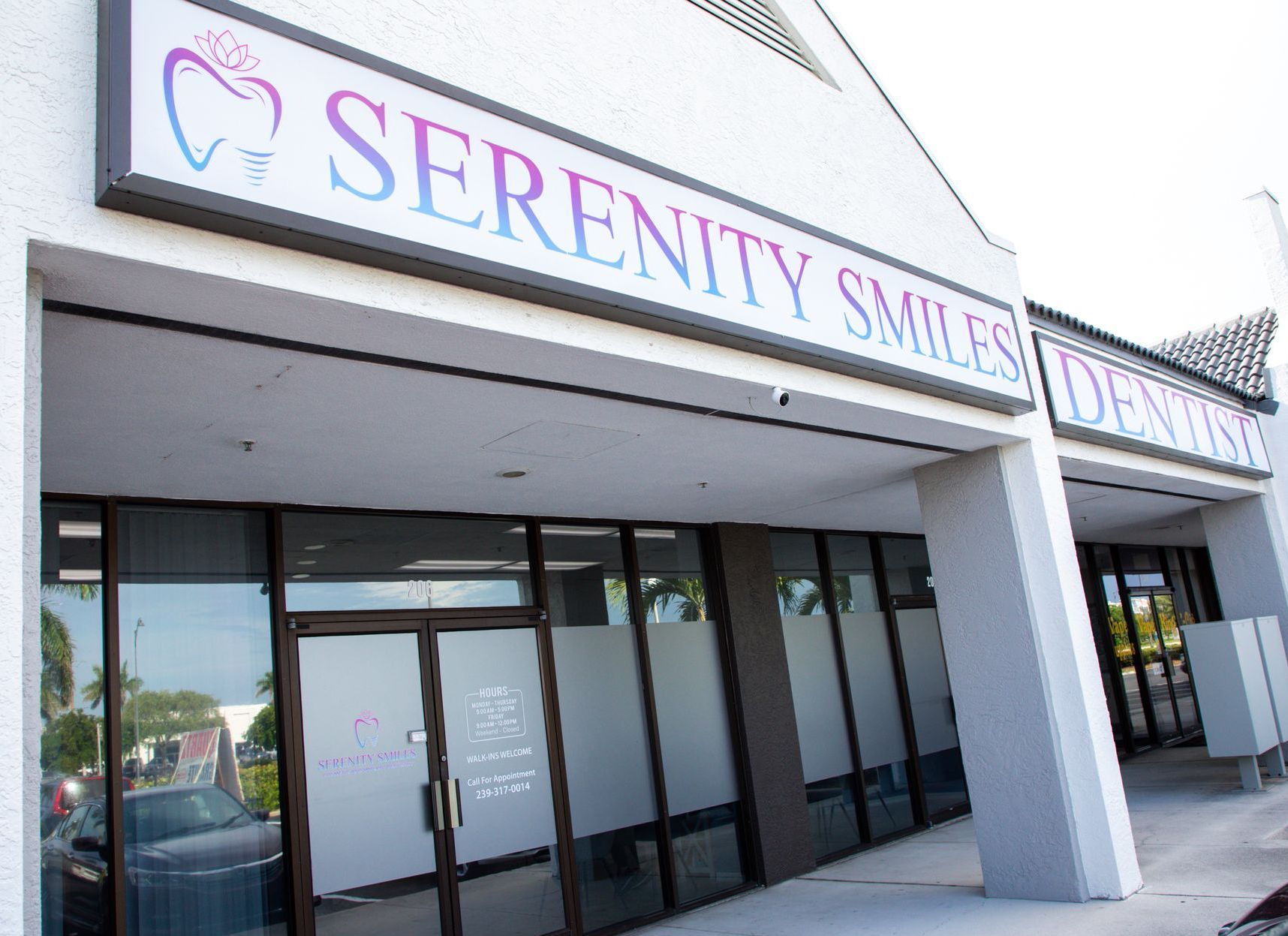 Serenity Smiles storefront with glass doors and purple sign on a sunny street