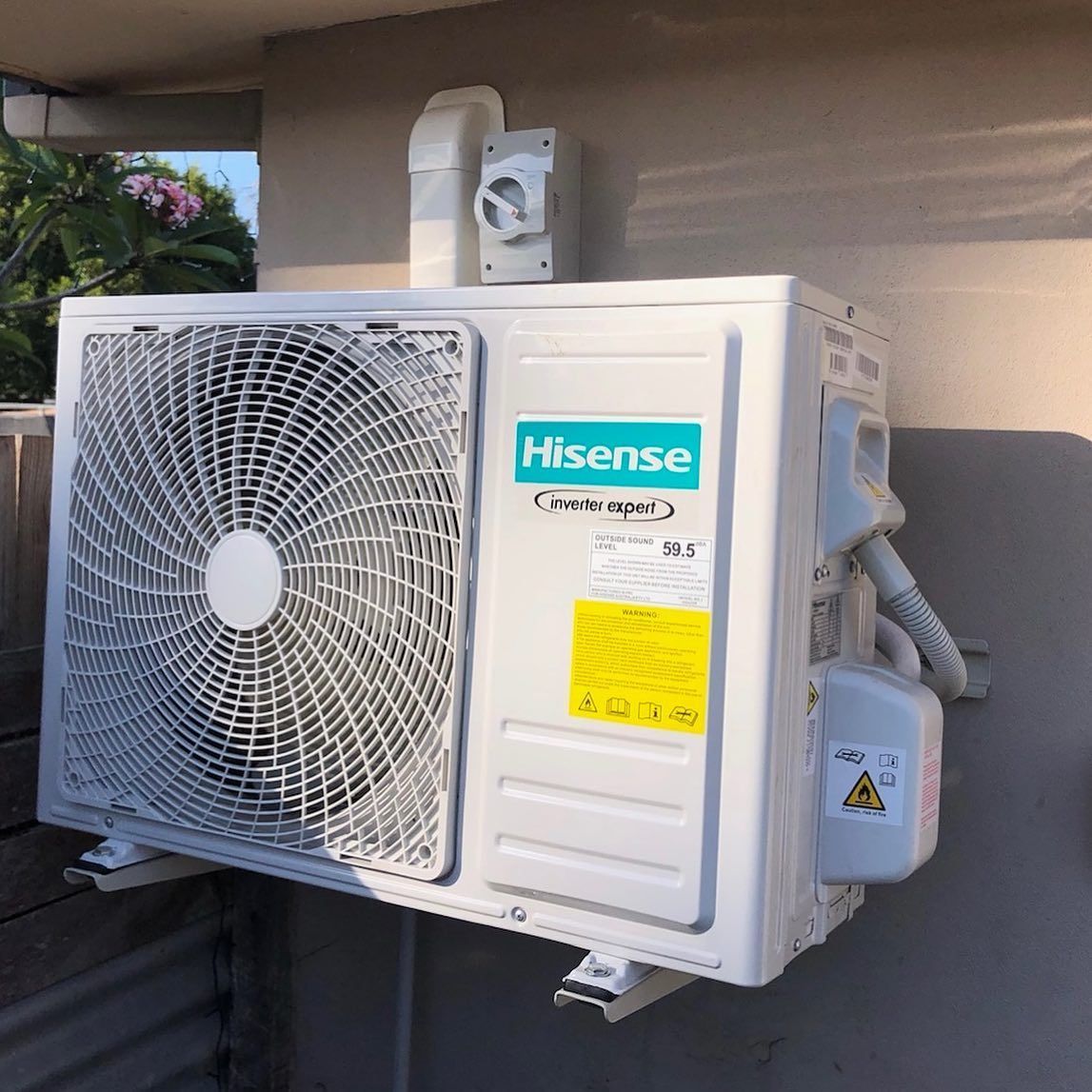 A Hisense Air Conditioner Is Mounted on The Side of A Building — Paton's Electrical Services in Urangan, QLD