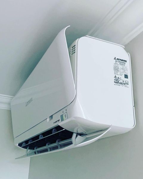 A White Air Conditioner Is Hanging from The Ceiling in A Room — Paton's Electrical Services in Torquay, QLD
