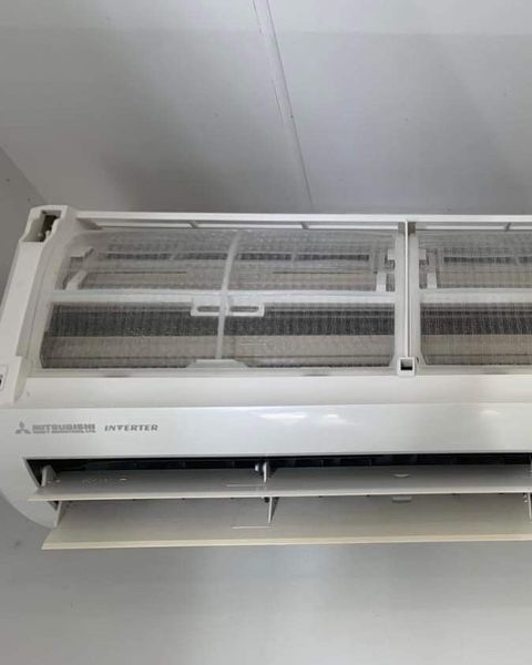 A White Air Conditioner Is Hanging from The Ceiling in A Room — Paton's Electrical Services in Craignish, QLD