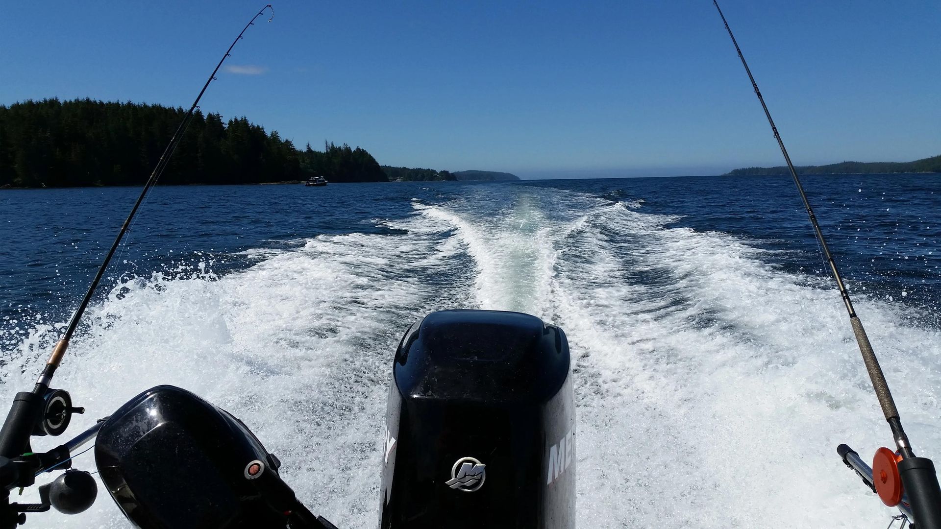 A mercury outboard motor is driving a boat on a lake