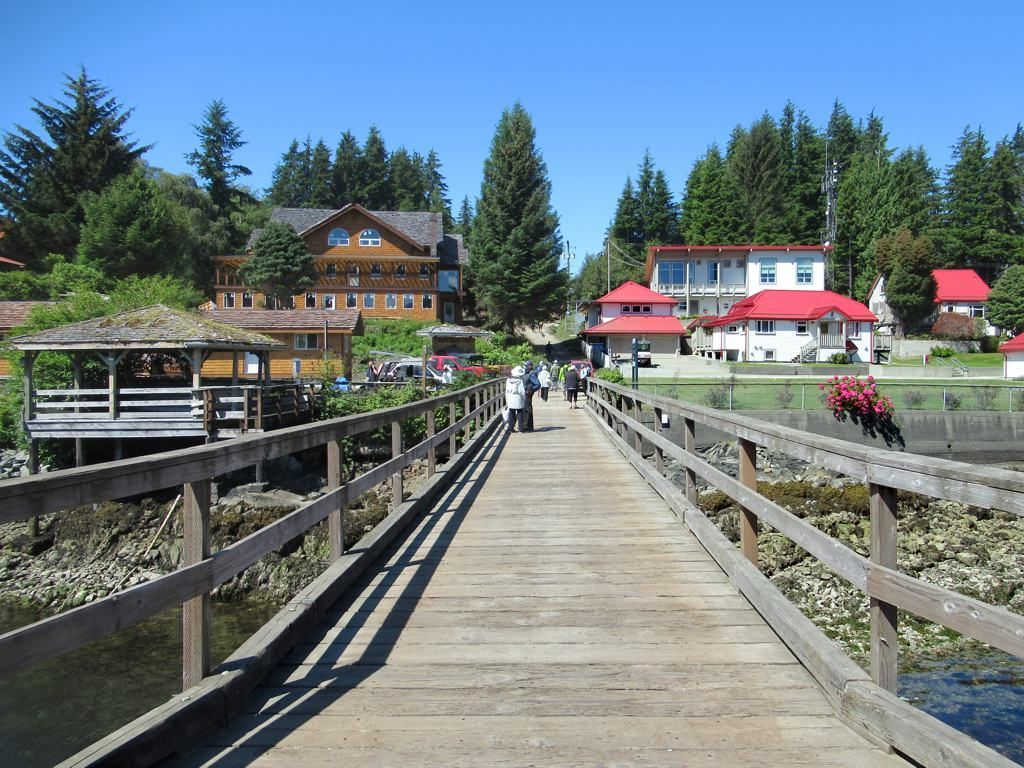 People are walking across a wooden bridge over a body of water