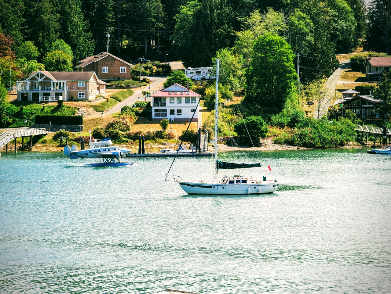 Sailboats find safe protected moorage in front of Woods End Landing in Bamfield Inlet on a sunny day