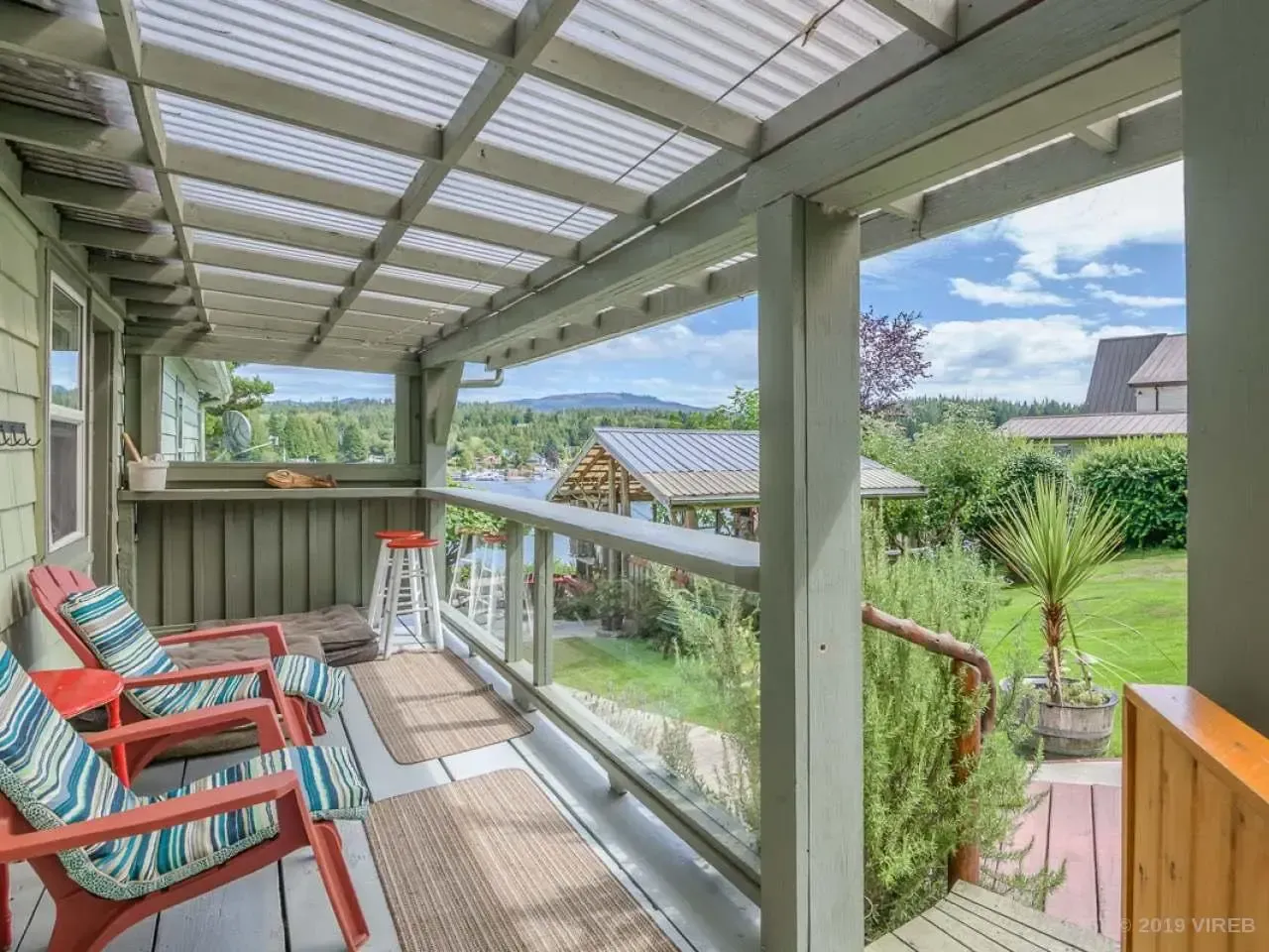 There is a porch with chairs and a ladder on it.