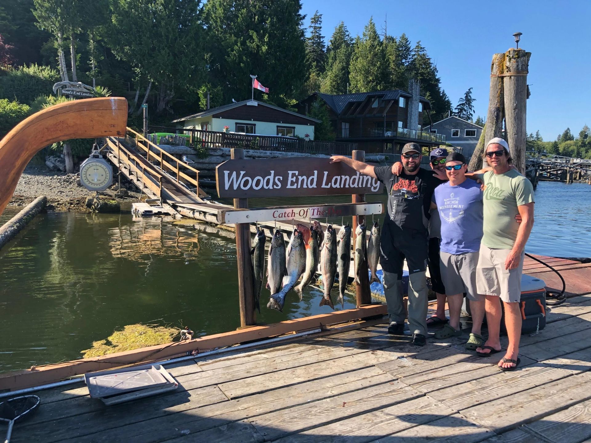 A group of men are standing on a dock next to a sign that says woods end landing.