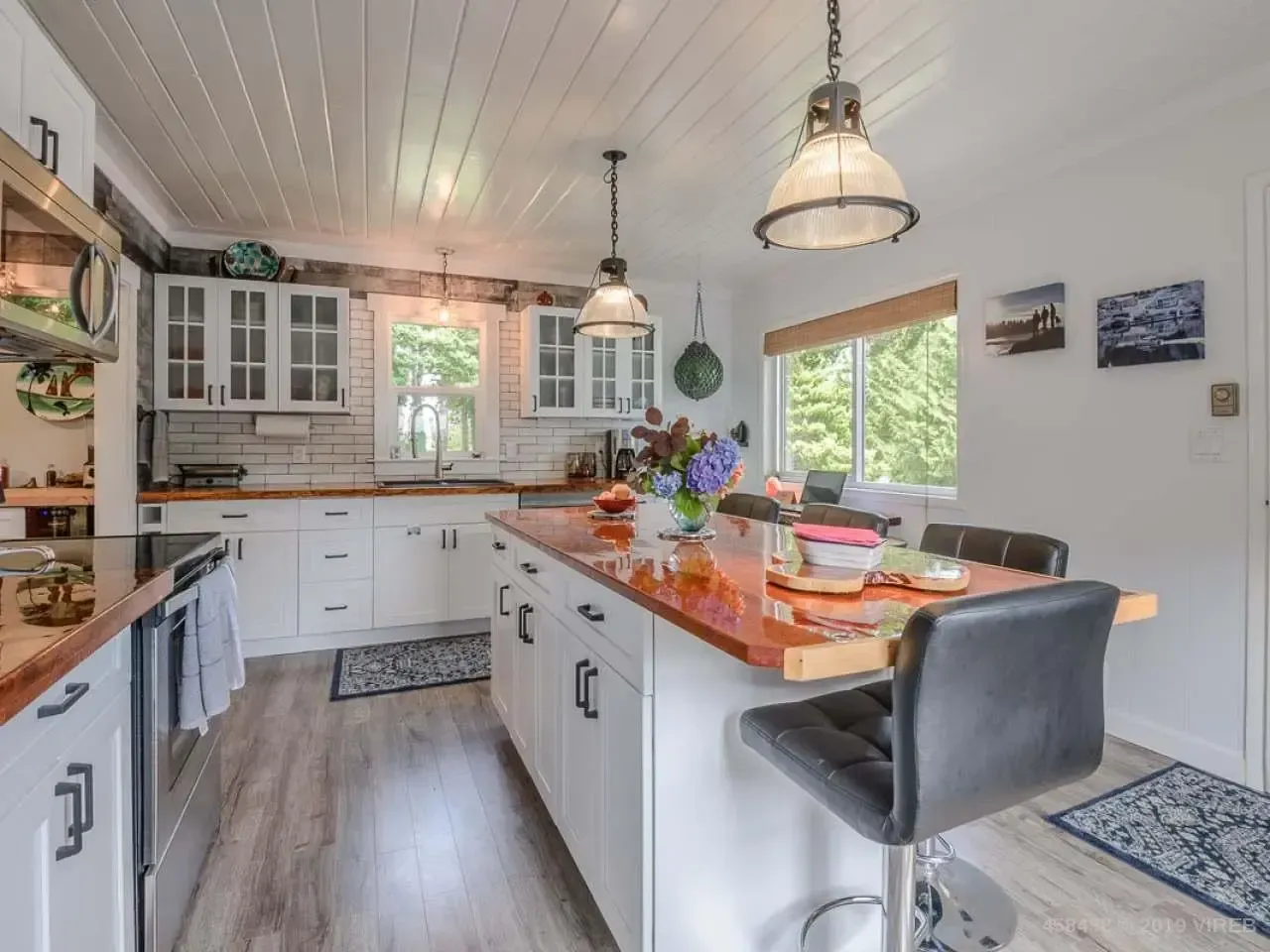 A kitchen with white cabinets and wooden counter tops