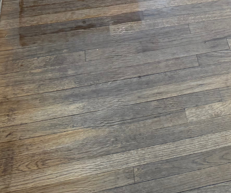 Gray-brown wooden floorboards with visible grain and seams