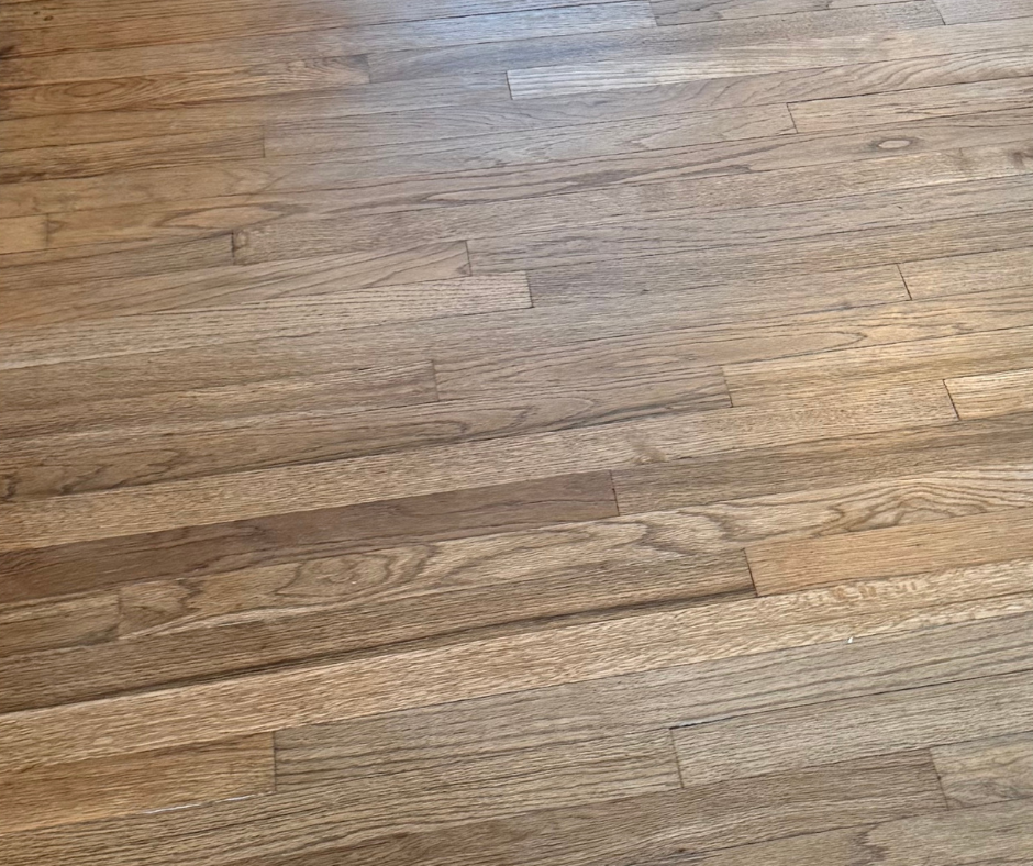 Close-up of a light brown wooden floor with visible plank grain and seams