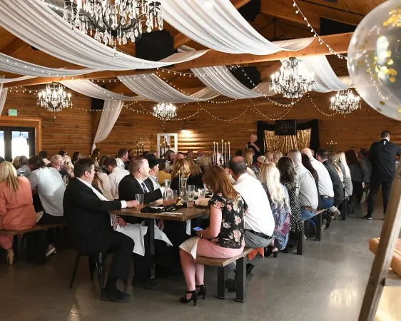 A large group of people are sitting at tables in a large room.
