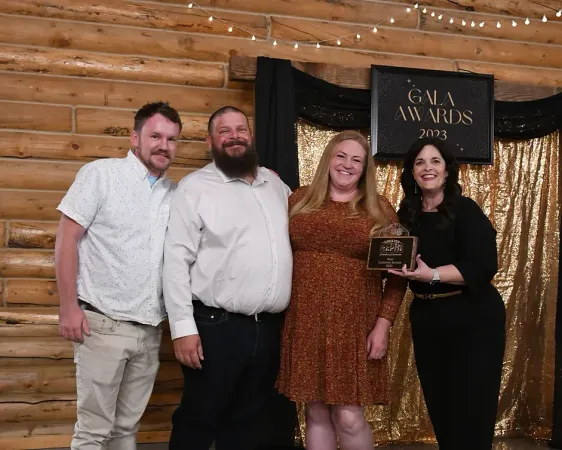 A group of people standing in front of a sign that says gala awards