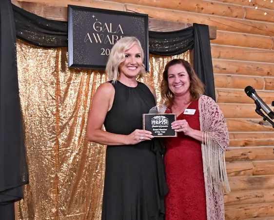 Two women are standing next to each other in front of a sign that says gala awards