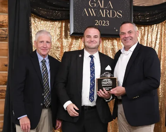 Three men are standing in front of a sign that says gala awards 2023