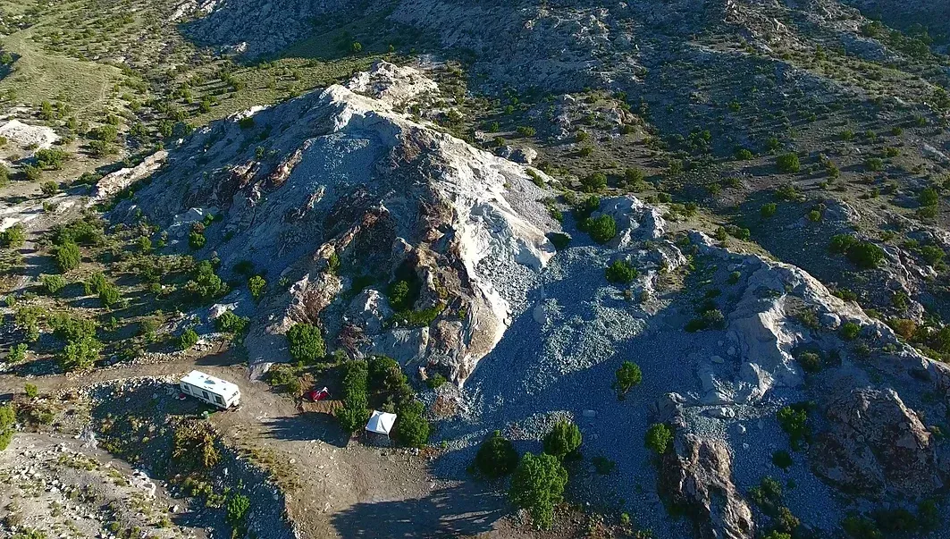 An aerial view of a mountain covered in trees and rocks.